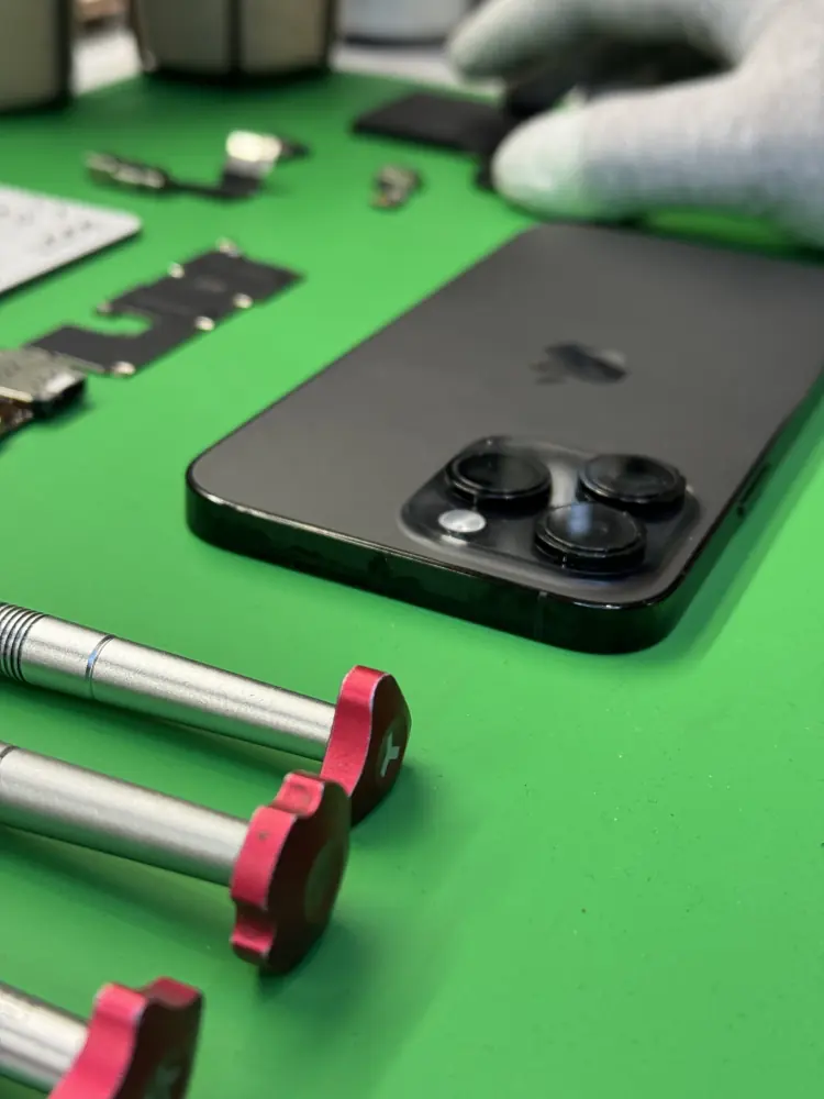 Aparaty iPhone Pro na macie, obok wkrętaki