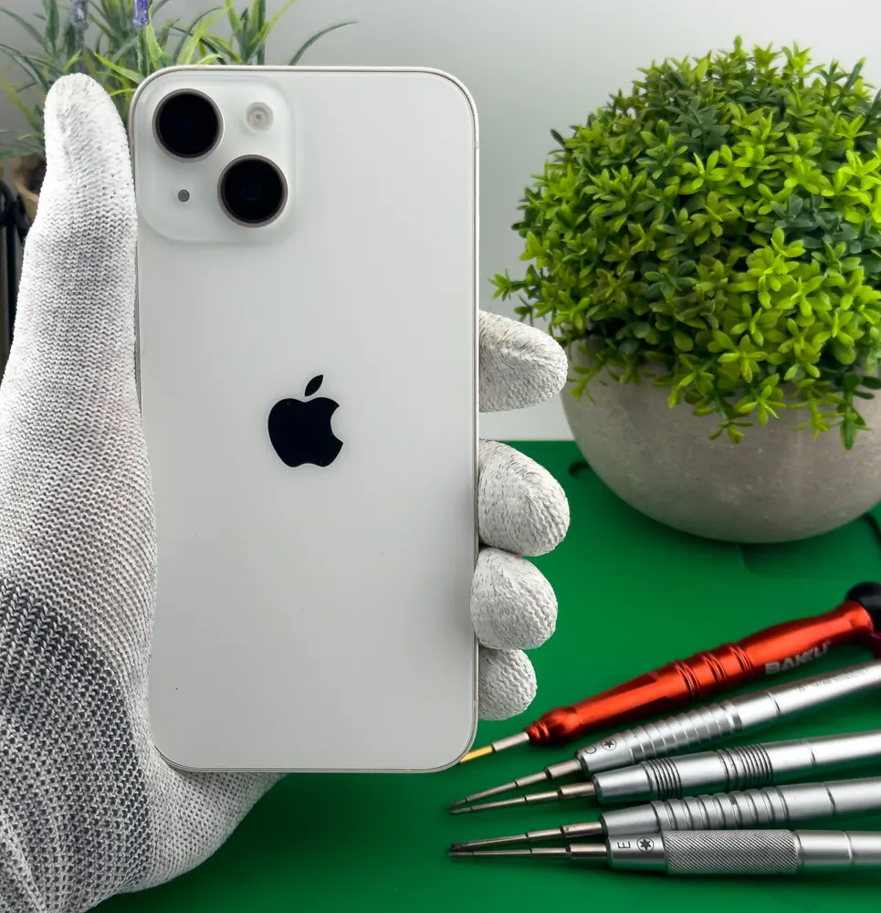 Biały iPhone w dłoni, widok tylnej szyby