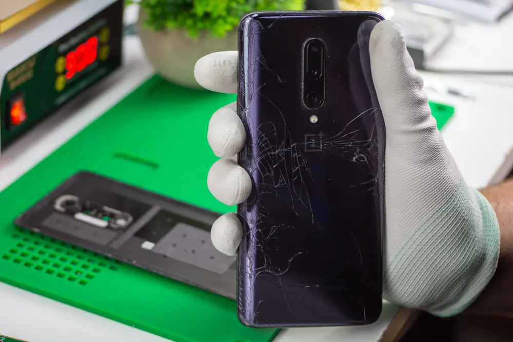 Telefon z porysowaną tylną szybą w dłoni