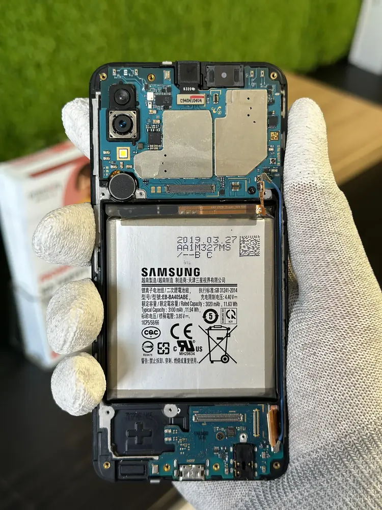 Otwarty telefon z baterią w dłoni