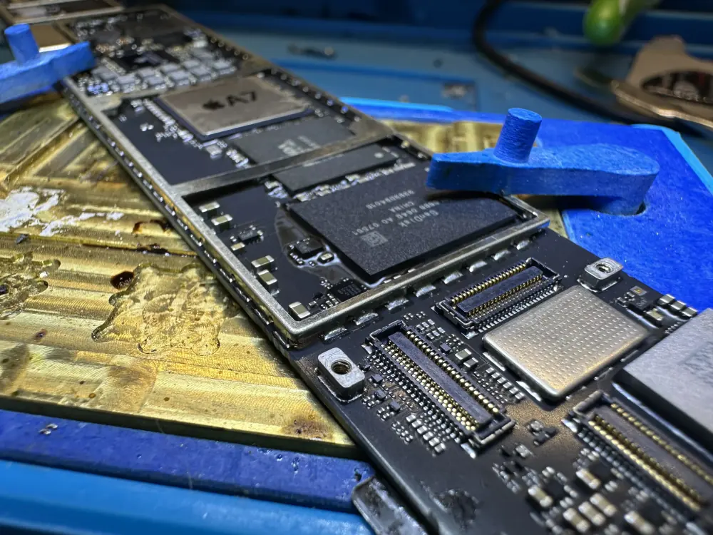Płyta główna iPhone w uchwycie, widok z boku