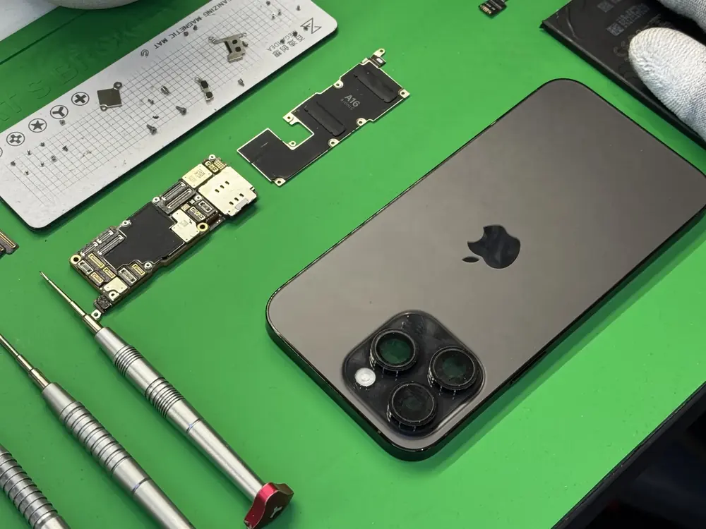 Rozłożony iPhone Pro i części na macie